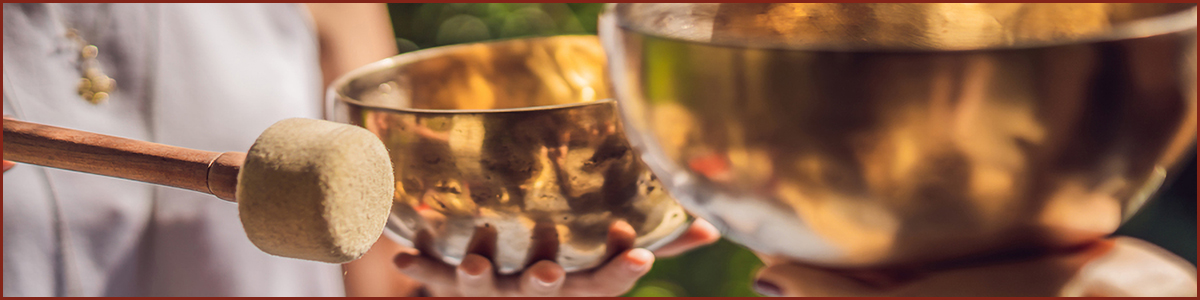 BANNER, LONG FORMAT Nepal Buddha copper singing bowl at spa salon. Young beautiful woman doing massage therapy singing bowls in the Spa against a waterfall. Sound therapy, recreation, meditation, healthy lifestyle and body care concept